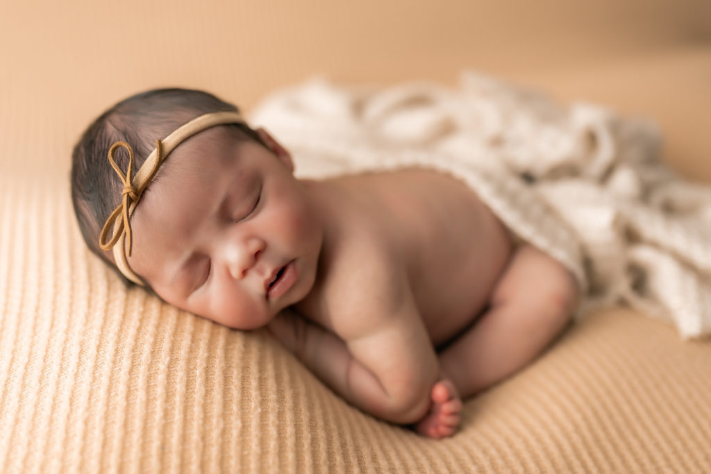 newborn-baby-in-taco-pose-on-beige-backdrop